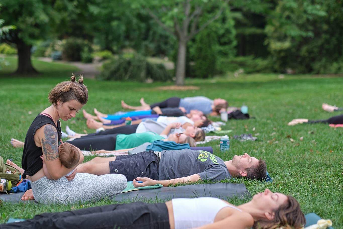 Mother nursing her son while others take savasana