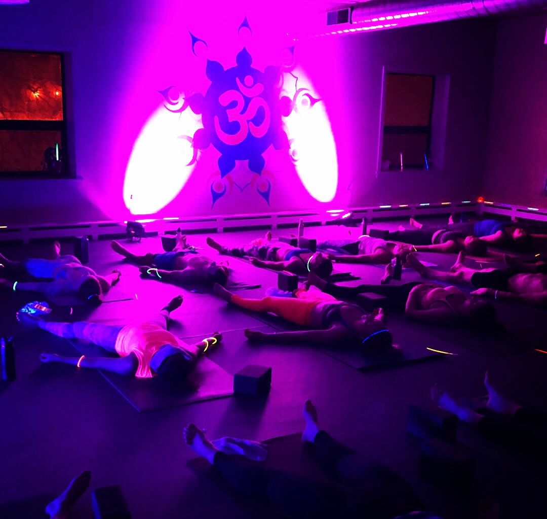 Glowga yoga participants in savansana