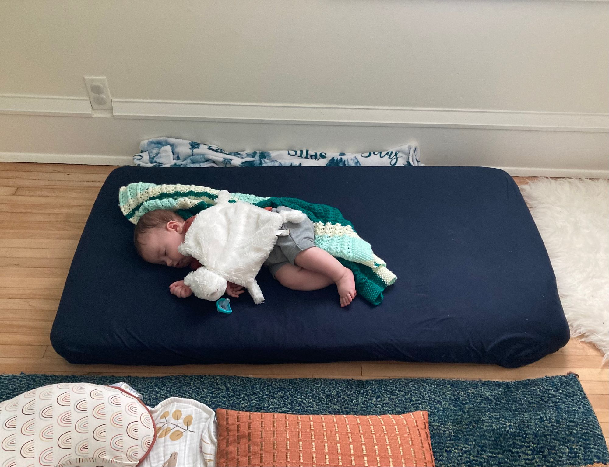 Infant sleeping on floor bed