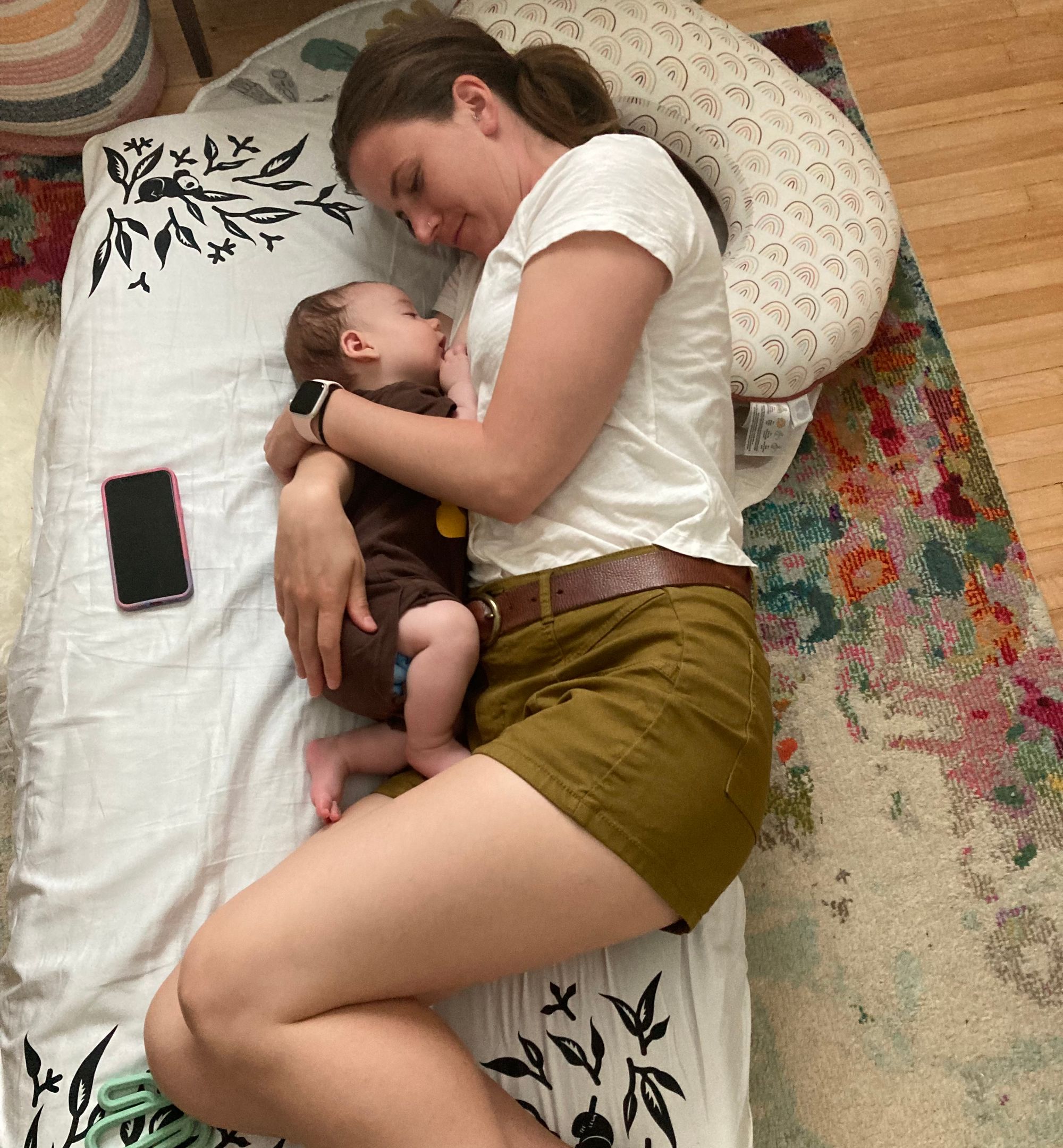 Infant sleeping on floor bed with mother